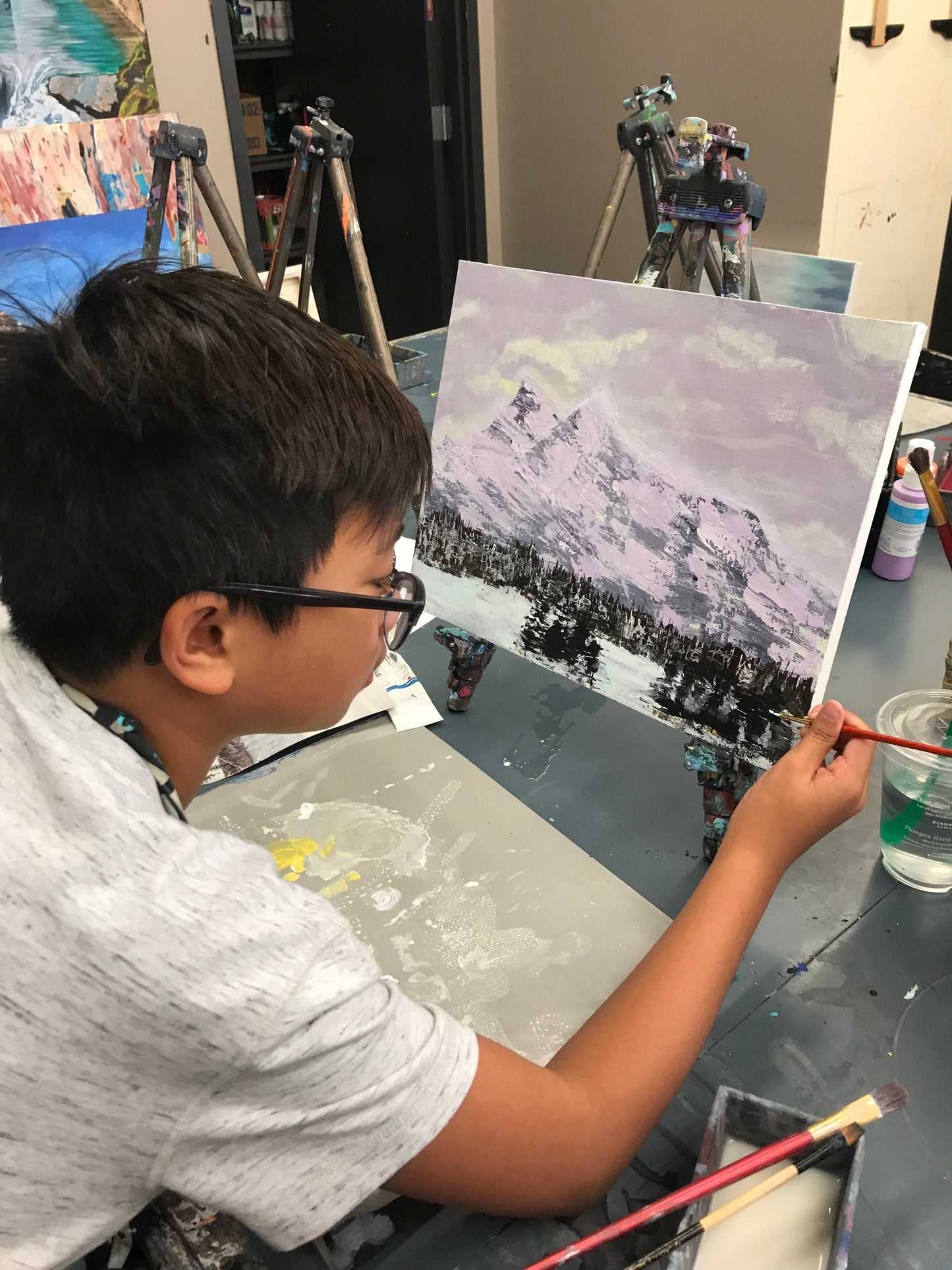 Young boy painting a winter landscape at Grasby Art Studio