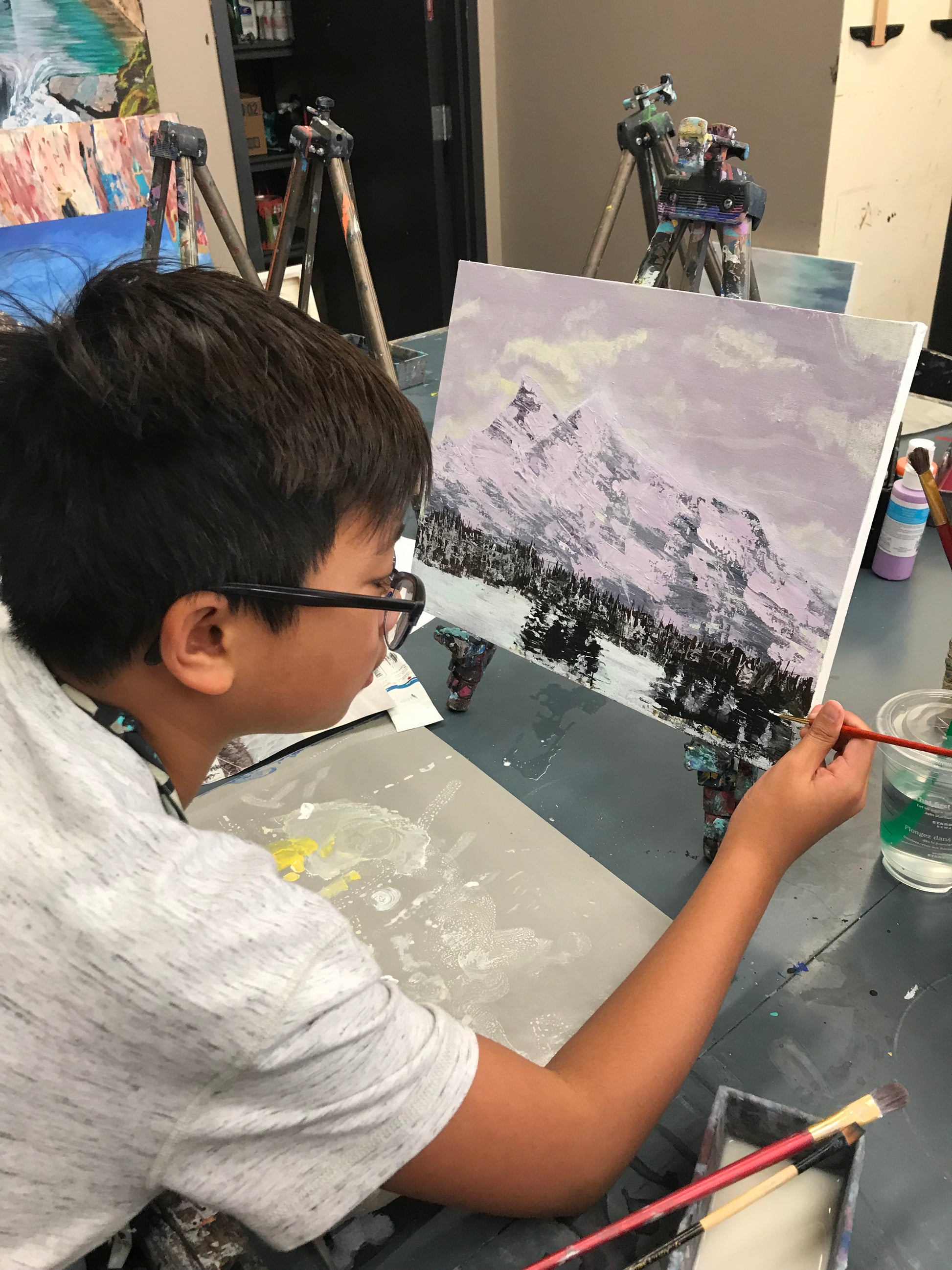 Young boy painting a winter landscape at Grasby Art Studio
