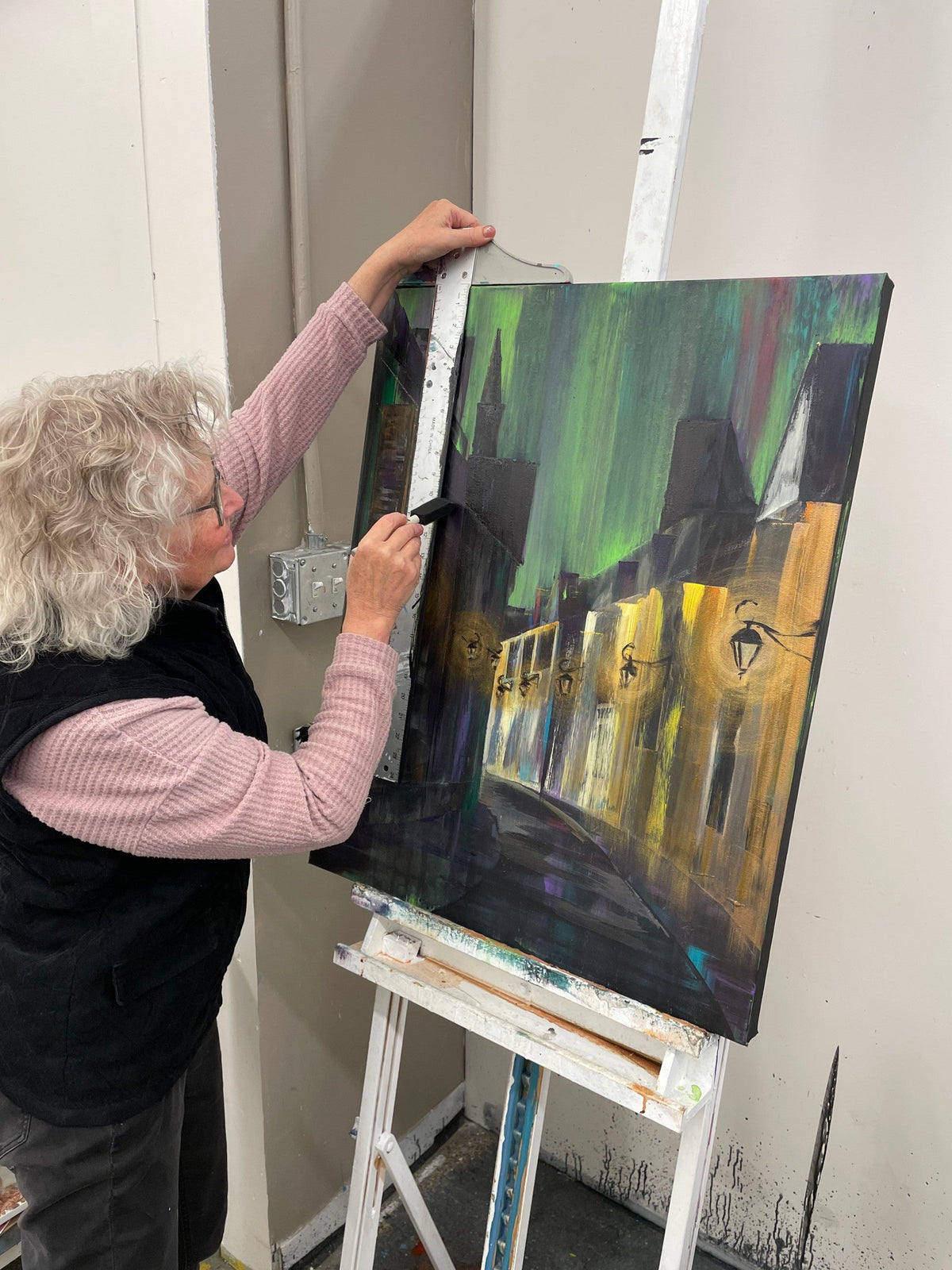 Student painting a lamplit street scene on canvas at the Cityscape Painting Workshop, Grasby Art Studio, NW Calgary